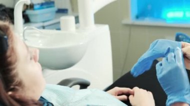diş hekimi istemci koyar yanındaki mavi koruyucu eldiven oturur.