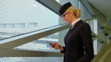Hostes smartphone ve gülümser bir mesaj okuyor.