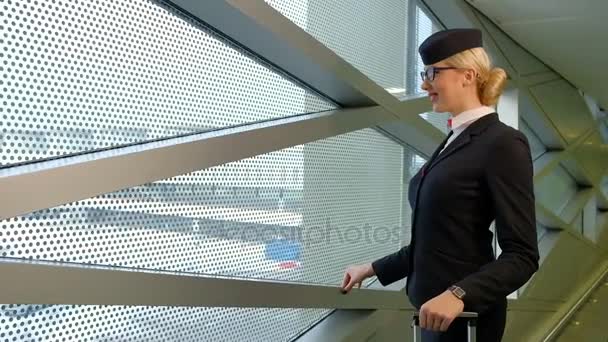 Stewardessa blondynka stoi w poczekalni przed lotem w pomieszczeniu — Wideo stockowe