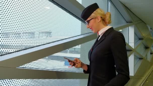 Stewardess az olvasó egy üzenetet a smartphone és a mosoly. — Stock videók