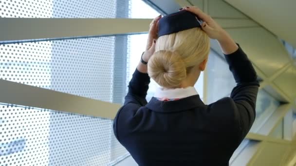 Blonde stewardess standing in waiting room wearing hat uniform — Stock Video