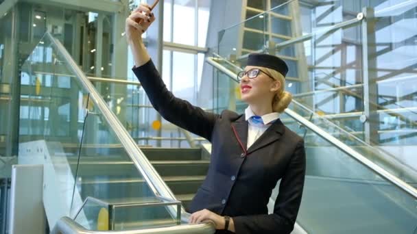 Blonde Stewardess steht auf Treppe und macht Selfie mit Smartphone — Stockvideo