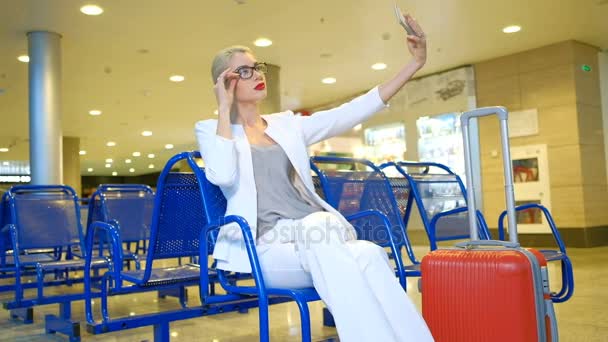 Pasajero en la sala de espera en el aeropuerto mirando hacia el interior del teléfono — Vídeos de Stock