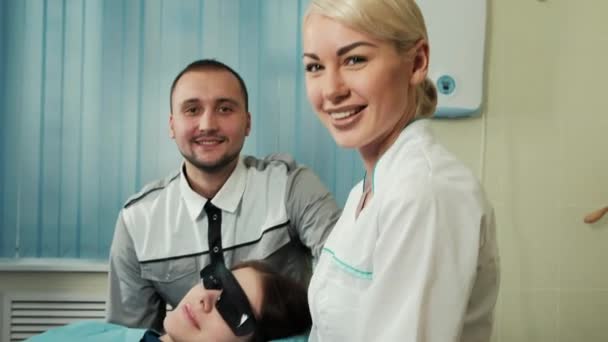 Equipe feliz de dentista e enfermeiro com paciente em consultório odontológico . — Vídeo de Stock