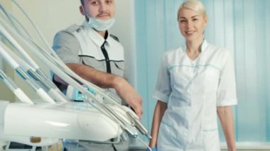 Diş hekimi Yardımcısı duruşu yakınındaki özel sandalyede mutlu hasta ile.