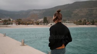 Kadın komik saç modeli ile deniz kenarındaki iskelede bir çalışma yapar.
