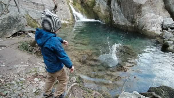 Charming boy plays near beautiful cascade. — Stock Video