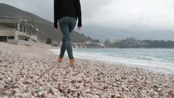 Schieten vanuit terug vrouw benen lopen op zee oever buiten. — Stockvideo