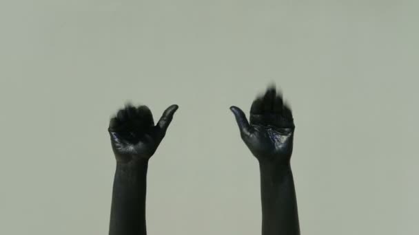 Актер мим с черными руками показывает жест прощания на сером фоне — стоковое видео