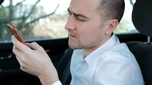 Arabada oturan sakallı genç ciddi adam ve telefon tutar — Stok video