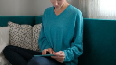 Tablet ile kanepede oturan kadın sarışın ev çalışma