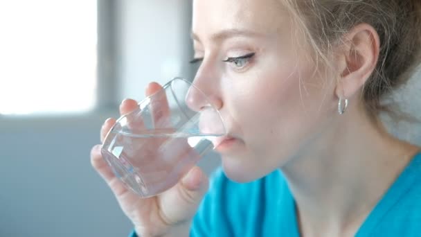 Close-up shooting of a woman face taking pills drinking water at home — Stock Video