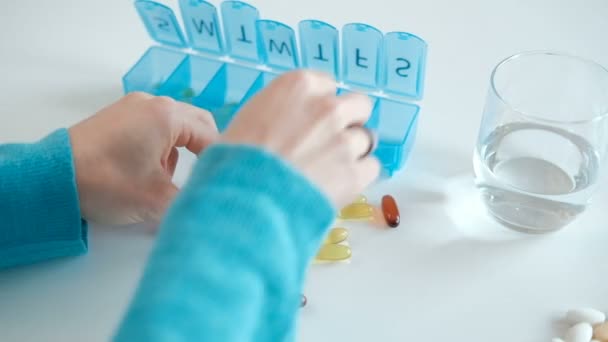 La femme met les capsules dans une boîte les jours de la semaine . — Video