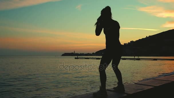 Athlete outline boxing into air on sea shore beach on sunset. — Stock Video