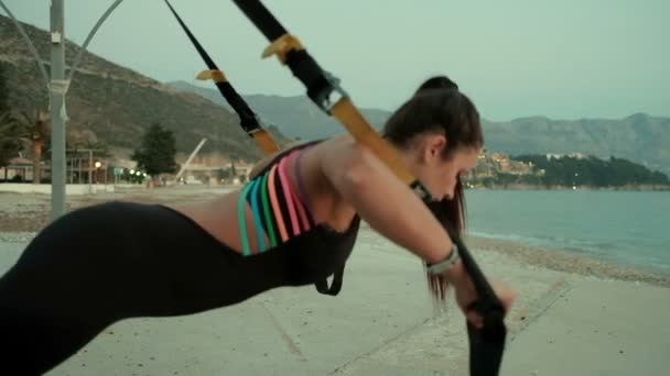 Athlète femme faire des exercices avec bande de fitness serrée à l'extérieur . — Video