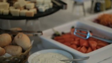 Açık büfe masanın üstüne farklı atıştırmalıklar ve sebze yemekleri vardır.