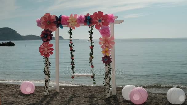 Sulla riva del mare oscillazione altalene vuote decorate con fiori e palle . — Video Stock