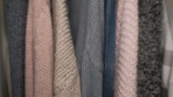 On the hanger hang warm woolen and denim things for women. — Stock Video