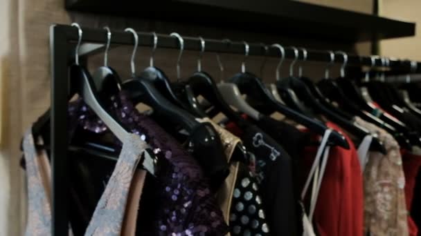 Coisas originais para mulheres penduradas em um cabide em uma boutique na moda . — Vídeo de Stock