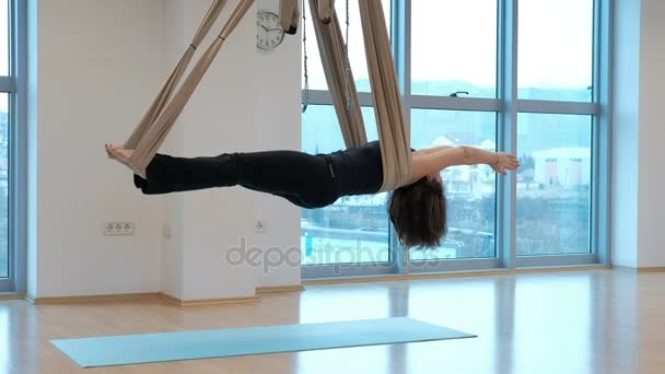 Kvinna i en hängmatta för yoga svänger i en utökad organ. — Stockvideo