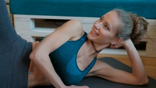 lächelnde Frau beim Workout auf dem Boden liegend.