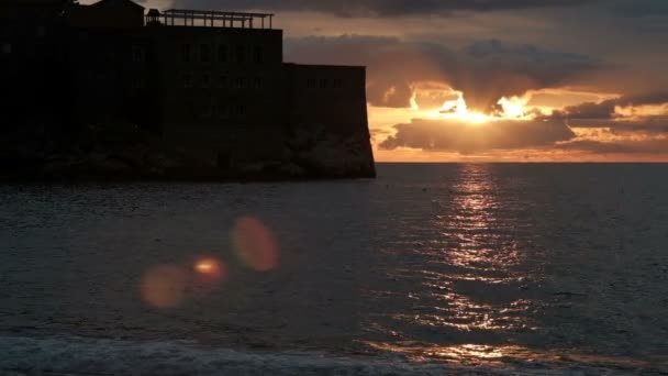 Een hoge stenen kasteel staat in het midden van de vijver bij zonsondergang. — Stockvideo