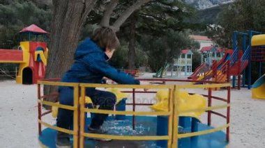 Küçük bir çocuk oyun alanında bir atlıkarınca at binme.
