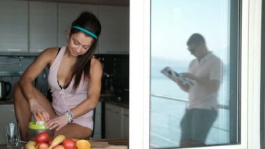 Bir kadın erkeğini meyve mutfakta kahvaltı hazırlanıyor.