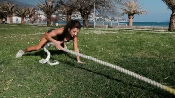 Mulher no treinamento sportswear puxa cabo grosso, hawser ao ar livre . — Vídeo de Stock