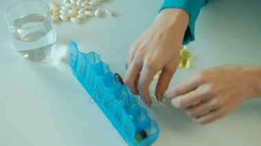 Kadın mavi tablet kutusunda beslenme vitamin hafta sıralar..