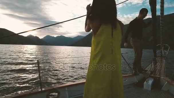 Two young people sailing on sailboat and dancing on deck outdoors. — Stock Video