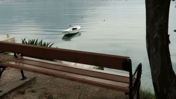 Slow shooting of river bank, bench and boat outdoors. — Stock Video