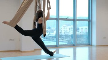 Genç kadının yapması için yoga kapalı hamak ile germe.