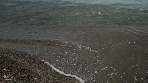 Långsam-rörelse av rörliga vågorna på stranden av sand utomhus — Stockvideo