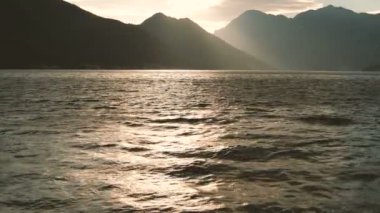 Yüksek dağlar horizon ile sakin bir deniz üzerinde büyüleyici gün batımı.