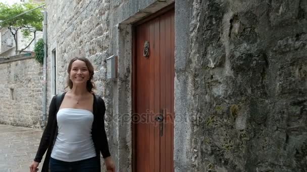 Mulher atraente com interesse examina uma rua estreita . — Vídeo de Stock