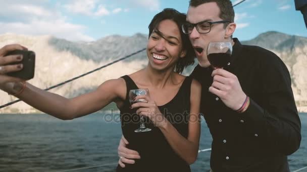 Couple joyeux boire du vin et faire téléphone selfie drôle . — Video