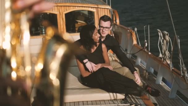 Verliefde paar knuffelen en luisteren naar een saxofonist op een schip op zee. — Stockvideo