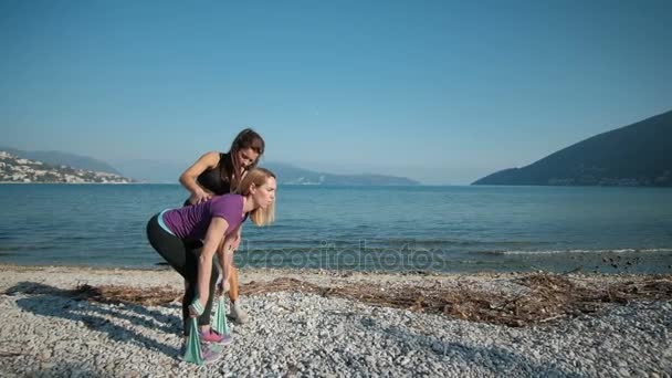 Fitness instruktor pomoci dělat cvičení klientům venku u jezera — Stock video