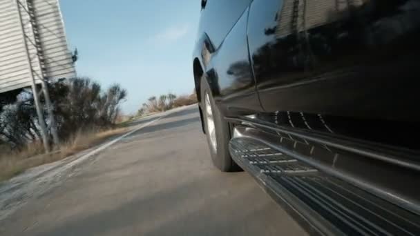 Zwarte auto is felle kleuren en modern met achterkant wiel en band close-up. — Stockvideo