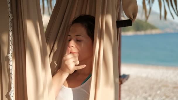 Mujer en una hamaca en la playa yoga respiración respiración alternativa . — Vídeos de Stock