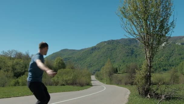 Young man riding gyroscooter on road in countryside. — Stock Video