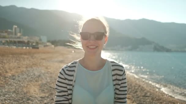 Mujer atractiva se encuentra en la playa de arena cerca del mar en solo . — Vídeos de Stock