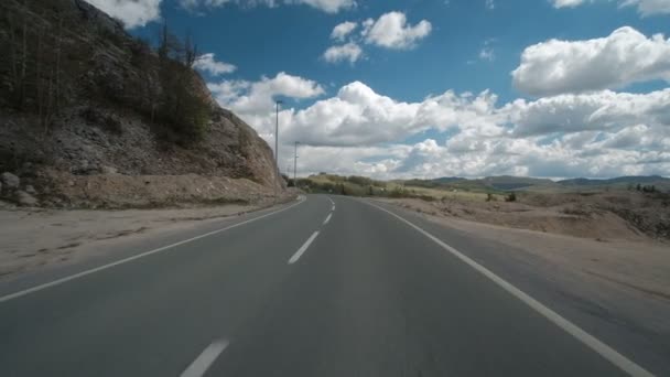 Auto rijdt langs een landweg in zomerdag. — Stockvideo