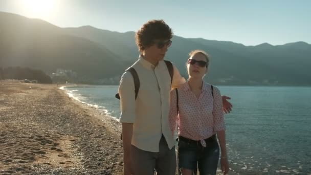 男と女の暖かいビーチに沿って歩く. — ストック動画