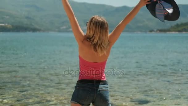 Mujer llegó al lago para relajarse en la playa al aire libre. Disparos por detrás — Vídeo de stock