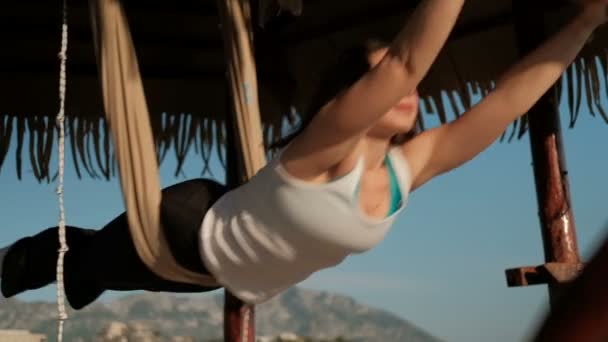 Deportiva Mujer haciendo ejercicio de yoga sobre vendaje de tejido al aire libre junto al lago — Vídeos de Stock