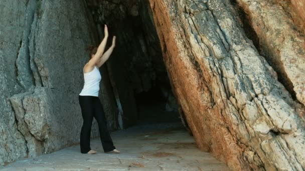 Athlète faisant des exercices abdominaux tenir debout à l'extérieur à travers des roches — Video