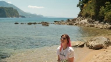 Genç kadın yaz günü sahilde ananas ayakta fırlatır.