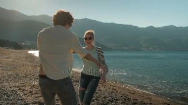 Erkek ve kadın yaz gün kumsalda dans.